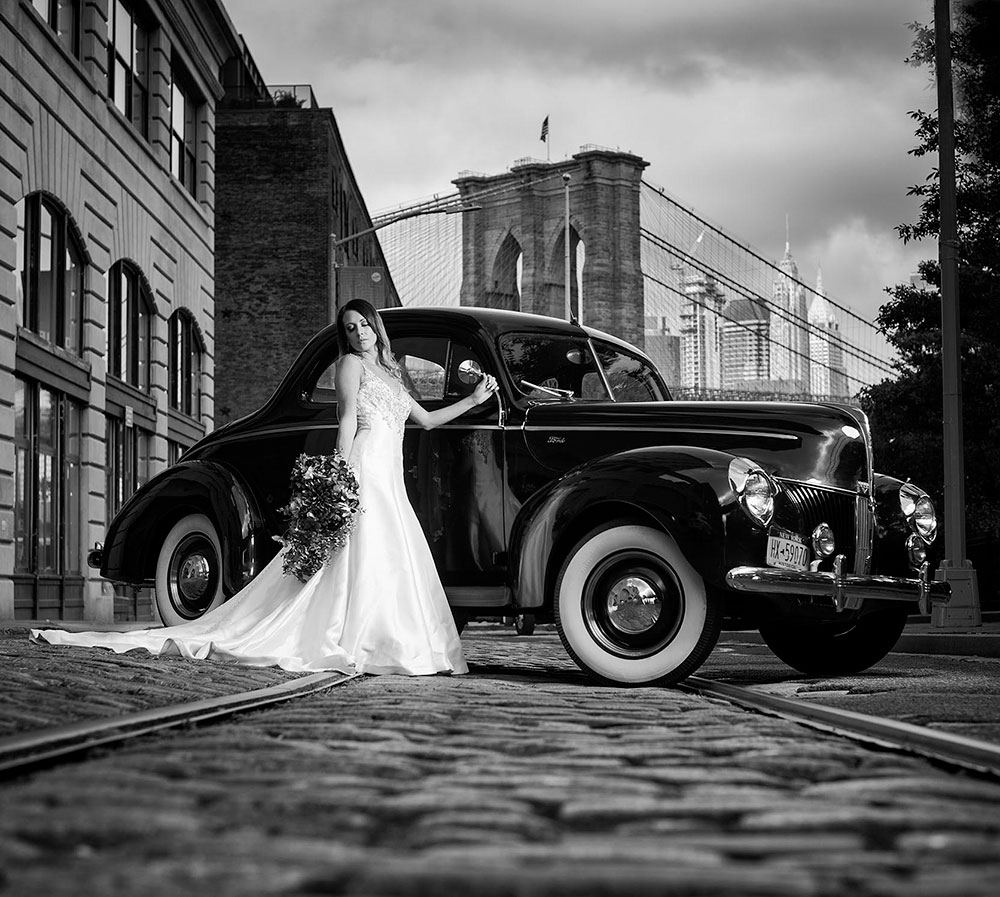 Bride standing in front of a classic car